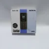 Nokia 105 Dual SIM feature phone in charcoal blue on a wooden desk showing the classic Snake game and built-in flashlight.